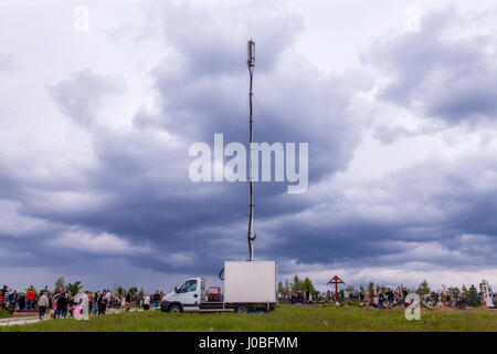 CHISINAU, Moldawien: Ein Handy-Mast ist errichtet, um Volumen von Menschen mit Mobiltelefonen auf dieses Ereignis zu behandeln. Besucher auf Europas größter Friedhof haben brachen das Brot mit den Toten gerissen worden. Was morbider klingt, ist in der Tat eine traditionelle Praxis in Chisinau, Moldawien. Bilder zeigen Horden von Menschen, die geliebt haben-diejenigen begraben in diesem gruseligen Friedhof einrichten und Picknicks um die Gräber zum Gedenken an die Verstorbenen auf spektakuläre Weise zu genießen. Während einige Jugendliche aus dieser orthodoxen christlichen Gemeinde nonchalant auf ihren Handys zu spielen gesehen werden können. Die weitläufige Landschaft Stockfoto