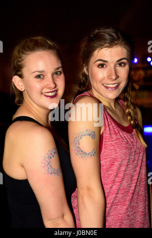 Zwei junge Frauen, (20 & 23 Jahre), Teilnahme an einem Charity-Zumbathon für Krebsforschung und tragen Krebsforschung Emblem auf ihren Arm, Alton, Hamps Stockfoto