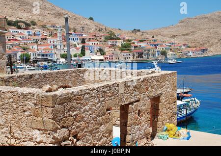 Ein verfallenes Gebäude steht über Emborio Hafen auf der griechischen Insel Chalki. Stockfoto