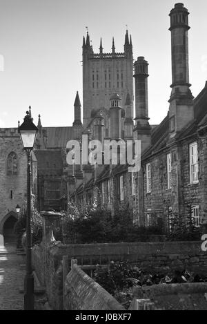 Ein b&w Bild der enge Vikare, einer mittelalterlichen Straße mit Turm von Wells Kathedrale im Hintergrund. Brunnen befindet sich in Somerset, England, UK Stockfoto