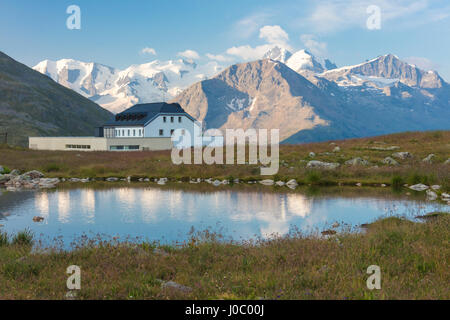 Der Alpensee rahmt das Hotel umgeben von Gipfeln, Muottas Muragl, Samedan, Kanton Graubünden, Engadin, Schweiz Stockfoto