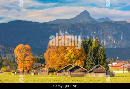 Holzhütten, umgeben von bunten Bäumen im Herbst, Garmisch Partenkirchen, Oberbayern, Deutschland Stockfoto