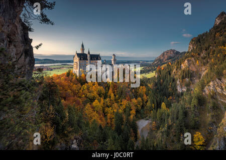 Dämmerung Leuchten am Schloss Neuschwanstein, umgeben von bunten Wäldern im Herbst, Füssen, Bayern, Deutschland Stockfoto