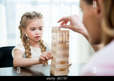 Mutter und konzentrierte kleine Tochter zu Hause Jenga Spiel Stockfoto