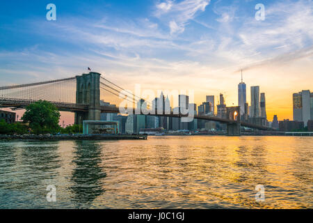 Brooklyn Bridge und Manhattan Skyline in der Abenddämmerung, angesehen vom East River, New York City, USA Stockfoto