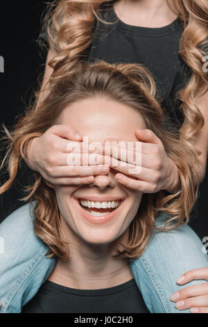 Tochter auf Mutters Schulter sitzt und schließen ihre Augen auf schwarz Stockfoto