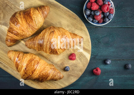 Knusprige französische Croissants mit frischen Himbeeren und Heidelbeeren Stockfoto