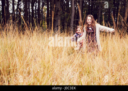 Zwei junge Mädchen laufen durch die Wiese, hand Stockfoto