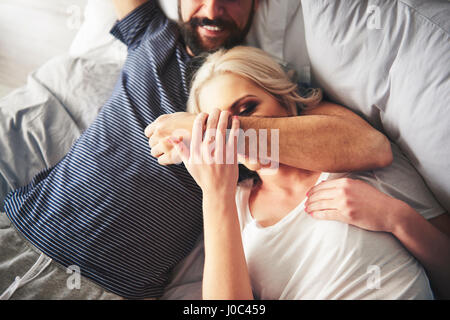 Paar, entspannend auf Bett, herumalbern Stockfoto