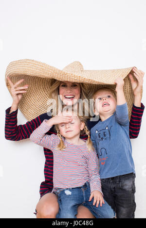 Frau trägt Sombrero, Abschirmung sich und zwei Kinder Stockfoto