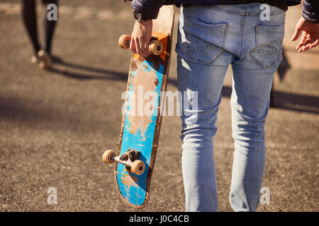 Junger Mann im freien laufen, tragen, Skateboard, Rückansicht, niedrigen Bereich, Bristol, UK Stockfoto