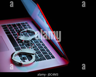 Netzwerksicherheit, set Handschellen sitzen auf Laptop-computer Stockfoto
