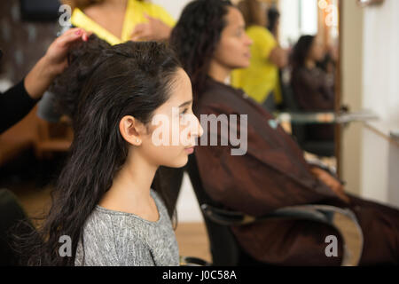 Mädchen und Mutter, die ihre Haare gestylt im Friseursalon Stockfoto