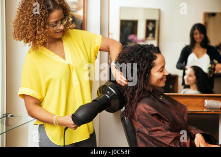 Friseur föhnen Haare weiblichen Kunden im Friseursalon Stockfoto