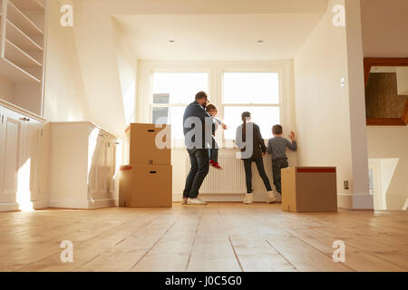 Mitte erwachsener Mann und drei Kindern aus Fenster neues Zuhause suchen Stockfoto