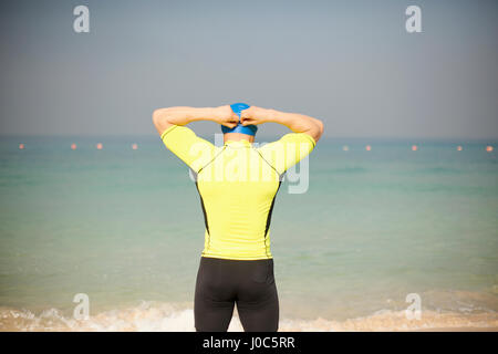 Heckansicht des reifen Mannes anpassen Badekappe am Strand, Dubai, Vereinigte Arabische Emirate Stockfoto