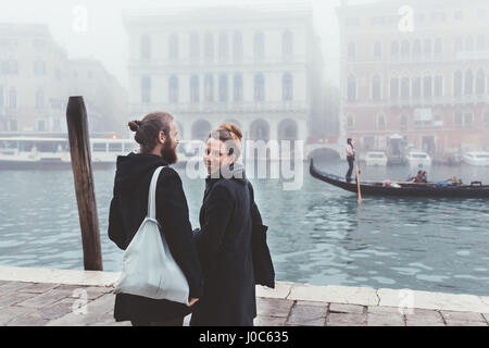 Rückansicht des Paares an nebligen Kanal Waterfront, Venedig, Italien Stockfoto