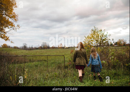 Mutter und Tochter, die Hand in Hand gehen auf Wiese, Lakefield, Ontario, Kanada Stockfoto