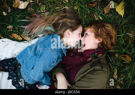 Mutter und Tochter liegen auf dem Rasen lustige Grimassen Stockfoto