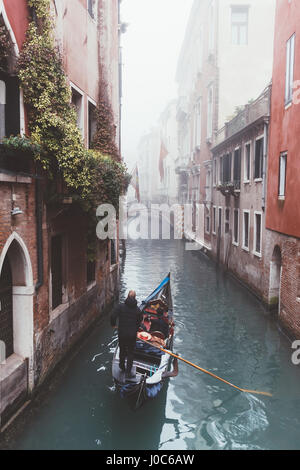 Erhöhten Blick auf Gondoliere am nebligen Kanal, Venedig, Italien Stockfoto