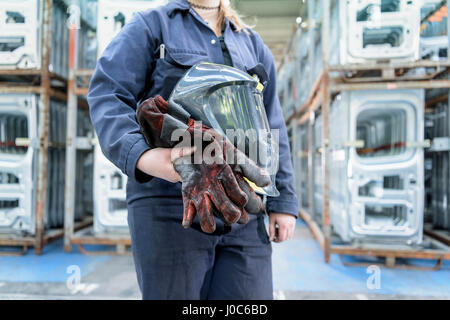 Weiblichen Lehrling Schweißer mit Ausrüstung in Autofabrik