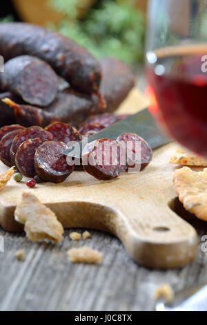 Südtiroler Marende mit typischen Wurstwaren ("Kaminwurzen") und knusprigen Fladenbrot (sogenannte Schuettelbrot), oft mit Wein aus der Region serviert Stockfoto