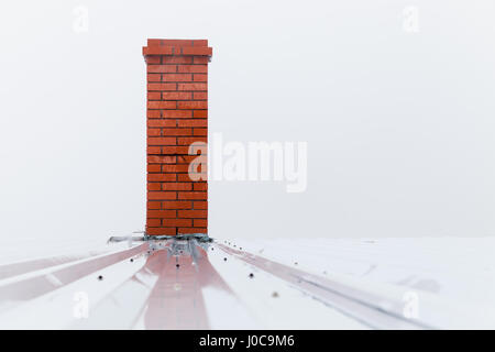 Schornstein aus rotem Ziegelstein über nebligen weißen Himmel gemacht. Stockfoto