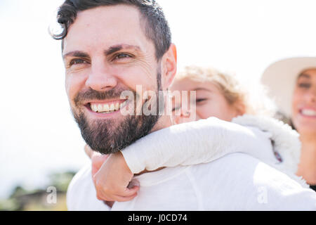 Mädchen mit Huckepack vom Vater an Küste Stockfoto