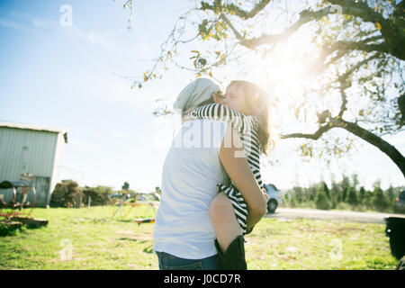 Mitte Erwachsene Frau und Tochter im sonnigen Park umarmt Stockfoto