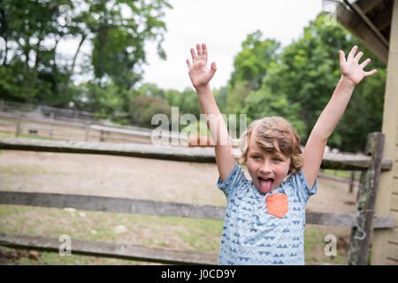 Porträt eines jungen mit Zunge heraus und Handzeichen Stockfoto