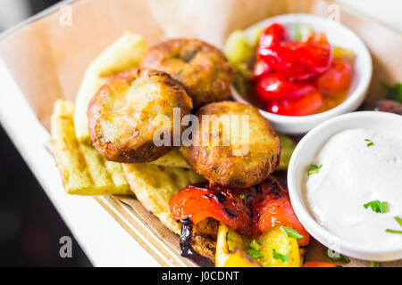 Frittierte Kartoffelbällchen auf einem Teller. Golden frittierte Kügelchen aus gestampften Kartoffeln, Eiern, Mehl, Salz und Kürbis Samen hergestellt. Vegetarisches Gericht. Closeup Stockfoto