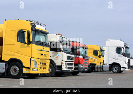 FORSSA, Finnland - 9. April 2017: Line-up der bunten neuen und gebrauchten Volvo und Scania halb LKWas auf Asphalt Hof an einem bewölkten Tag. Stockfoto