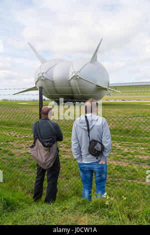 Cardington, Bedfordshire, UK. 11. April 2017. Zuschauer beobachten, wie die Hybrid Air Fahrzeuge Airlander 10, die neue Mobile Mooring Mast (MMM), eine integrierte Kettenfahrzeug vor Anker liegt und Liegeplatz Mast, wodurch es leichter zu kontrollieren und die Airlander "zurückdrängen" beim Rangieren sie um den Flugplatz. Das Flugzeug soll es ist 2017 Flugerprobungsprogramm in diesem Monat beginnen. Zuschauer und Fotografen warten im Vorgriff auf den Erstflug. Bildnachweis: Mick Flynn/Alamy Live-Nachrichten Stockfoto