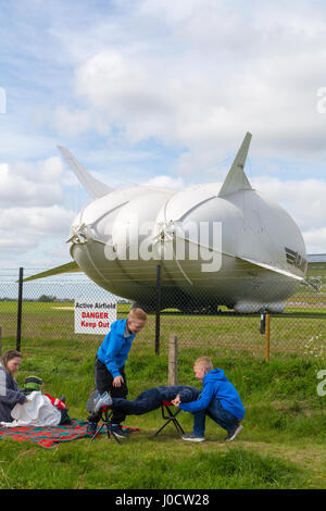 Cardington, Bedfordshire, UK. 11. April 2017. Zuschauer beobachten, wie die Hybrid Air Fahrzeuge Airlander 10, die neue Mobile Mooring Mast (MMM), eine integrierte Kettenfahrzeug vor Anker liegt und Liegeplatz Mast, wodurch es leichter zu kontrollieren und die Airlander "zurückdrängen" beim Rangieren sie um den Flugplatz. Das Flugzeug soll es ist 2017 Flugerprobungsprogramm in diesem Monat beginnen. Zuschauer und Fotografen warten im Vorgriff auf den Erstflug. Bildnachweis: Mick Flynn/Alamy Live-Nachrichten Stockfoto