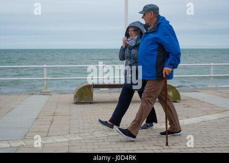 Aberystwyth Wales UK.  Mittwoch, 12. April 2017 UK Wetter: kalter, grau, windiger und bewölkter Tag in Aberystwyth, Wales, wie Menschen Fuß entlang der Strandpromenade im Vorfeld bis Ostern Urlaubswochenende Foto Keith Morris / Alamy Live News Stockfoto