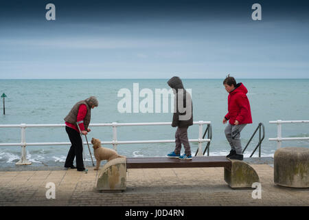 Aberystwyth Wales UK.  Mittwoch, 12. April 2017 UK Wetter: kalter, grau, windiger und bewölkter Tag in Aberystwyth, Wales, wie Menschen Fuß entlang der Strandpromenade im Vorfeld bis Ostern Urlaubswochenende Foto Keith Morris / Alamy Live News Stockfoto