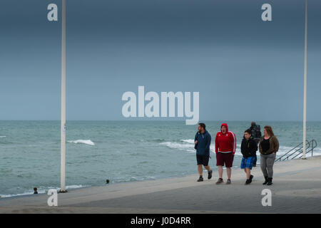 Aberystwyth Wales UK.  Mittwoch, 12. April 2017 UK Wetter: kalter, grau, windiger und bewölkter Tag in Aberystwyth, Wales, wie Familien Fuß entlang der Strandpromenade im Vorfeld bis Ostern Urlaubswochenende Foto Keith Morris / Alamy Live News Stockfoto