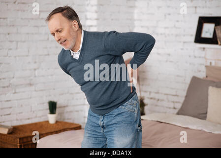 Sehr plötzlich. Senior woman Gefühl Beschwerden beim stehen wegen Schmerzen im Rücken. Stockfoto