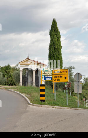 MEDANA, Slowenien - 27. September 2016: Verkehrszeichen und kleine Oratorium am Eingang zum Dorf. Medana liegt in den Hügeln von Görz, einen Wein pro Stockfoto