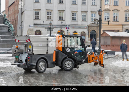 Krakau, Polen - 12. Januar 2017: Unbekannter Treiber funktioniert auf kleinen Schneefräse LKW am Hauptplatz der Stadt Marktplatz (Rynek Glowny). Krakau ist die sec Stockfoto