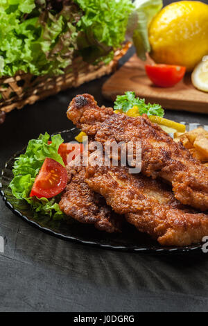 Gebratener Fisch in knuspriger Teig mit Chips auf einem Teller Stockfoto