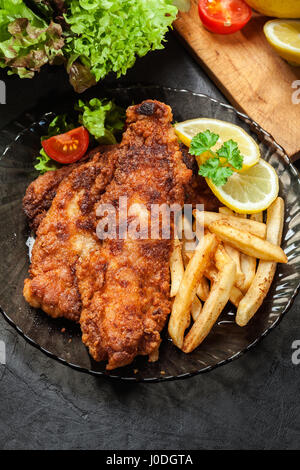 Gebratener Fisch in knuspriger Teig mit Chips auf einem Teller Stockfoto