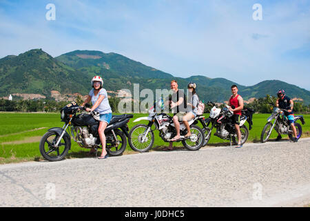 Horizontale Porträt einer Gruppe von Touristen auf einer Motorradtour aufgereiht für ein Foto auf dem Land in Vietnam. Stockfoto