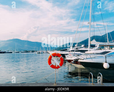 Rettungsring in der Marina für Yachten. Roter Kreis auf dem Bootssteg. Stockfoto
