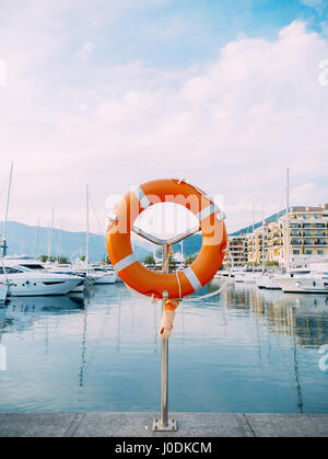 Rettungsring in der Marina für Yachten. Roter Kreis auf dem Bootssteg. Stockfoto
