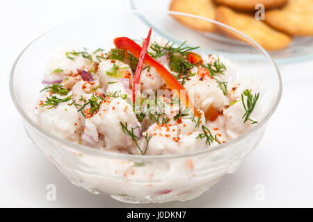 Peruanische Ceviche Vorbereitung: weißer Fisch peruanische Ceviche in einer durchsichtigen Schüssel mit Cracker serviert Stockfoto