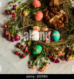 Ostern Essen: Osterkuchen, gefärbten Eiern, Glas mit Gänseleber, Süßigkeiten, hausgemachte Bratwurst, gekochtes Schweinefleisch, Ei aus weißer Schokolade am Heu gelegt Stockfoto