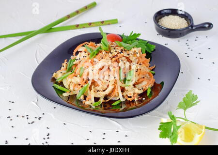 Koreanische traditionelle Speisen. Rohem Hühnerfleisch mariniert mit Gemüse auf einer schwarzen Platte auf einem weißen abstrakten Hintergrund. einfaches Kochen. Gesunde Ernährung. Stockfoto