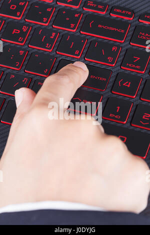 Finger drückt enter-Taste auf der Laptoptastatur Stockfoto