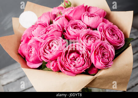 Rosa Pfingstrose Misty Bläschen. Bouquet Blumen rosa Rosen in Glasvase auf dunklen grauen rustikalen hölzernen Hintergrund. Shabby chic Wohnkultur. Stockfoto